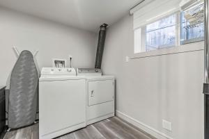 a washing machine in a room with a window at Bright & Cozy Central Retreat in Calgary +21 photos