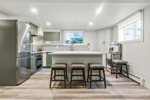 a kitchen with a counter and stools in it at Bright & Cozy Central Retreat in Calgary