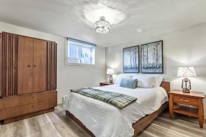 a bedroom with a large bed and a wooden cabinet at Bright & Cozy Central Retreat in Calgary