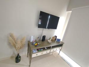 a room with a table with a tv on the wall at Mendoza in Posadas