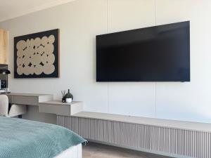 a bedroom with a flat screen tv on a white wall at Unit 4913 - Ellipse Waterfall in Midrand