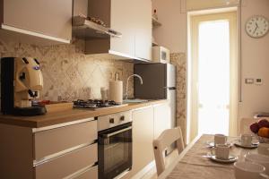 a kitchen with white cabinets and a table with a table at vivaldi casa vacanza in Caserta