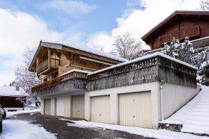 a house with two garage doors in the snow at Chalet Savoyard in La Clusaz
