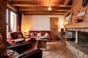 a living room with leather furniture and a fireplace at Chalet Savoyard in La Clusaz