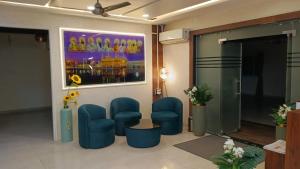 a lobby with blue chairs and a painting on the wall at Hotel Singh Empire in Sāgar