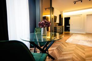 a glass table with a vase of flowers in a living room at Ghica Boutique Suites in Vaslui