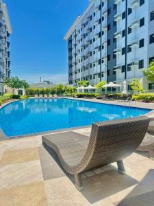 a swimming pool with a chair next to a building at Golden Maison de Luxe in Manila