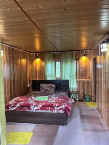 a bedroom with a bed in a room with wooden walls at Tamu Kyi Retreat in Kaluk