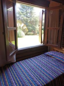 a room with a window with a bed and a view at Cabañas El Tala in Villa la Bolsa