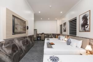 a hotel room with two beds and a flat screen tv at Nghia Lan Maison - DL Center in Da Lat