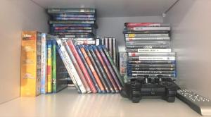 a shelf with a bunch of books and a video game controller at Family-friendly apartement in Lumbrein