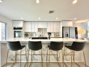 a kitchen with a large white counter with black appliances at Arlington Beach House - by Yale in West Haven +31 photos