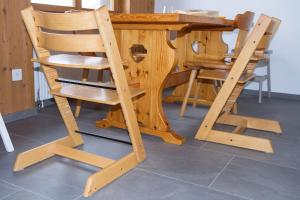 a wooden dining room table with a wooden chair at Family-friendly apartement in Lumbrein