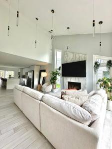 a living room with a large couch and a fireplace at Arlington Beach House - by Yale in West Haven