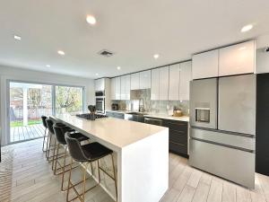 a kitchen with a large white island with bar stools at Arlington Beach House - by Yale in West Haven