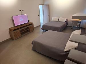 a hotel room with two beds and a flat screen tv at Hotel La Casona - Cerca al Estadio Atanasio Girardot y Laureles in Medellín