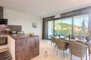 a kitchen with a table and chairs and a large window at Villa Bella Vista 2 in Ičići