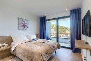 a bedroom with a large bed and a large window at Villa Bella Vista 2 in Ičići
