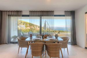 a dining room with a table and chairs and a large window at Villa Bella Vista 2 in Ičići