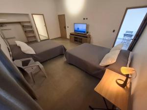 a hotel room with two beds and a television at Hotel La Casona - Cerca al Estadio Atanasio Girardot y Laureles in Medellín +69 photos
