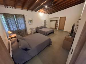 a bedroom with two beds and a television in it at Hotel La Casona - Cerca al Estadio Atanasio Girardot y Laureles in Medellín