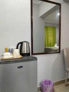 a mirror on top of a refrigerator in a room at Oloks Guest Inn in Francistown +15 photos