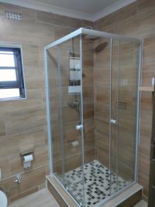 a shower with a glass enclosure in a bathroom at Oloks Guest Inn in Francistown