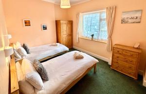 a bedroom with two beds and a window at Ocean View in Ilfracombe