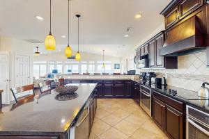 a large kitchen with wooden cabinets and a counter top at NTB106 Scotch Bonnet Sunrise in North Topsail Beach