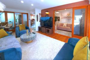 a living room with blue couches and a flat screen tv at PALMIE Gold in Palm Beach