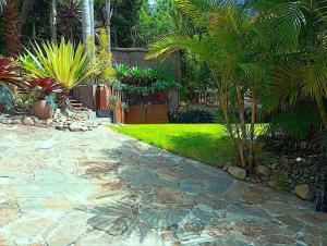 a garden with palm trees and a stone walkway at PALMIE Gold in Palm Beach
