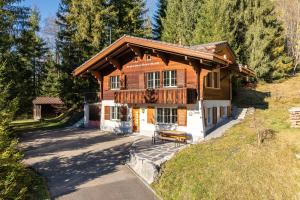 a large wooden house with a porch at Chalet Spatz Loft with Sauna Kandersteg Oeschinen Lake in Kandersteg