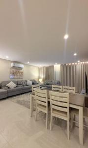 a living room with a table and chairs and a couch at AINOSAH Residences in Medina