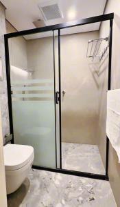 a bathroom with a glass shower with a toilet at AINOSAH Residences in Medina