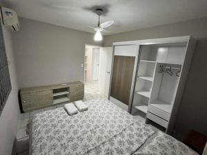 a bedroom with a bed and a dresser and shelves at Residencial Larissa Elena in Florianópolis