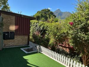 a backyard with a white fence and green grass at Mispa George in George +12 photos