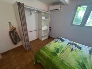a small bedroom with a bed and a window at Kay Nono in Rivière-Salée