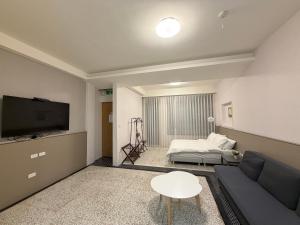 a living room with a couch and a tv at 簃居青衖 in Tainan