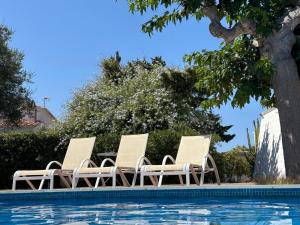 a group of chairs sitting next to a swimming pool at Starbal Love in Es Castell