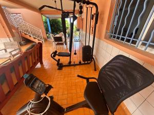 a room with a gym with a chair and a treadmill at Kay Nono in Rivière-Salée