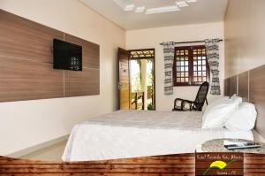 um quarto com uma cama e uma televisão na parede em Hotel Fazenda Ceu Aberto em Gravatá