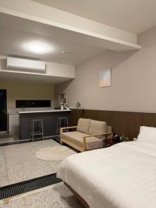 a hotel room with a bed and a kitchen at 簃居青衖 in Tainan