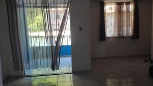 a room with sliding glass doors and a tile floor at Quarto em Casa Completa no Centro de Ilhéus in Ilhéus