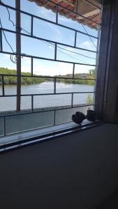 a room with a window looking out at a river at Quarto em Casa Completa no Centro de Ilhéus in Ilhéus