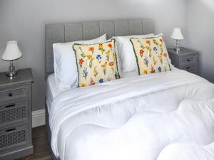 a white bed with two night stands and two lamps at Oak Park One - Uk50062 in Tiverton