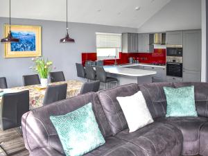 a living room with a brown couch and a kitchen at Oak Park One - Uk50062 in Tiverton