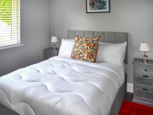 a bedroom with a white bed with two night stands at Oak Park One - Uk50062 in Tiverton +10 photos