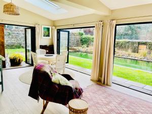 a living room with a couch and a table and windows at Garden House Barmeath Castle in Grangebellew +11 photos