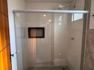 a shower with a glass door in a bathroom at Pousada Estalagem Da Serra in Serra do Cipo