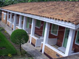 an old house with white columns and a tile roof at Kivu Hotel Resort in Kibuye